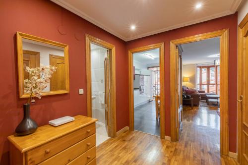- un salon avec des murs orange et une commode en bois dans l'établissement Txurruka - baskeyrentals, à Mutriku