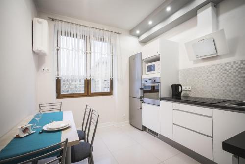 a kitchen and dining room with a table and chairs at Glamour Residence in Warsaw