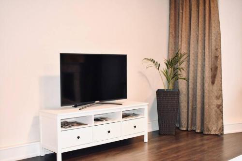 a white entertainment center with a flat screen tv on it at Scarbantia Casa in Sopron