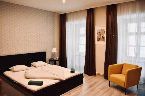 1 dormitorio con 1 cama y 1 silla amarilla en Scarbantia Casa, en Sopron