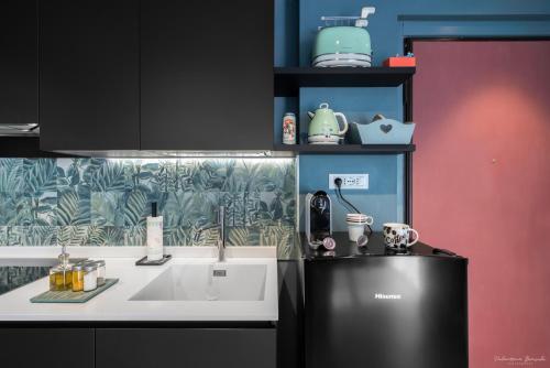 een keuken met een zwarte koelkast en een wastafel bij Draisina Bike Apartments DUE in Oleggio Castello