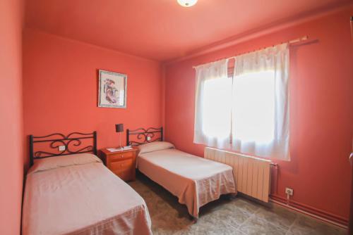 1 dormitorio rojo con 2 camas y ventana en Club Villamar - Rubia, en Calonge