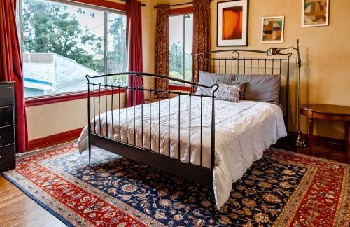 a bedroom with a bed and a large window at Beautiful, Historic Family Home near Lake Merritt in Oakland