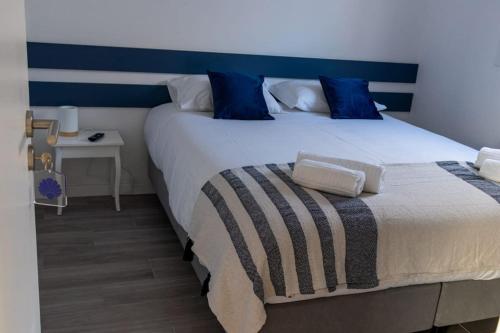 a bedroom with a large bed with a blue headboard at Perto do Mar, Alojamento Local - Espaço T2 privativo in Vagos