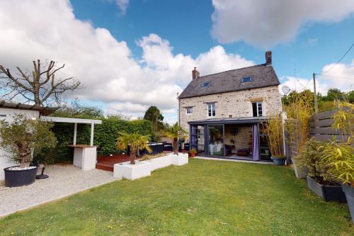 a house with a yard with plants in front of it at Les 3 Pommiers : gîte en Suisse Normande in Donnay
