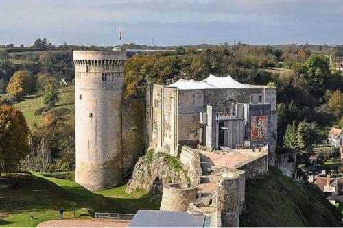 an old castle on a hill with at Les 3 Pommiers : gîte en Suisse Normande in Donnay