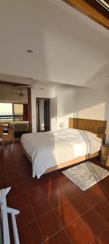 une chambre avec un grand lit blanc dans une pièce dans l'établissement Apartment with a stunning view over Sesimbra, à Sesimbra