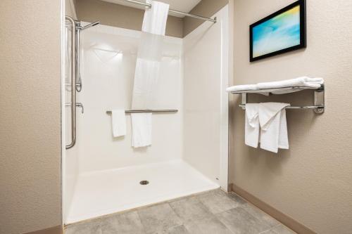 a bathroom with a shower with white towels at Home Inn and Suites Lloydminster in Lloydminster