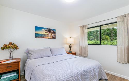 a white bedroom with a bed and a window at Hawaiian Plantation Style Home in Mountain View in Mountain View