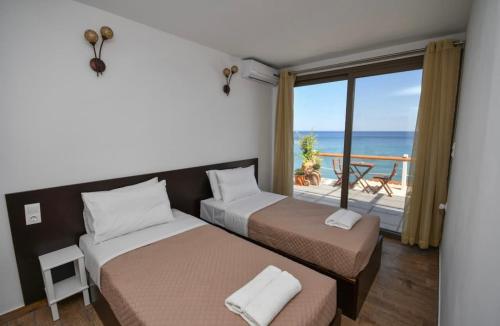 een slaapkamer met 2 bedden en uitzicht op de oceaan bij Ferma Beach Villas in Ferma