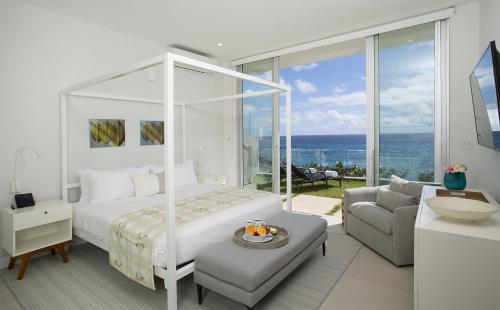 a bedroom with a bed and a living room with a view at Azura Bermuda in Bermuda