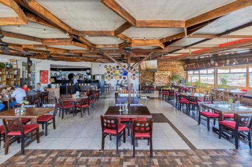 un restaurant avec des tables et des chaises et des personnes en arrière-plan dans l'établissement First Inn Hotel & Business, à Texcoco de Mora