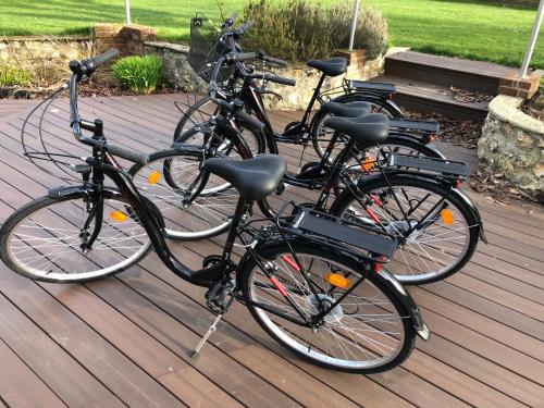 3 vélos garés l'un à côté de l'autre sur une terrasse en bois dans l'établissement le coin dla rue, à Fécamp