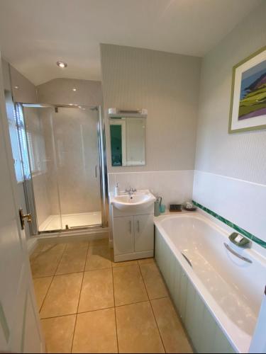 La salle de bains est pourvue d'une baignoire, d'un lavabo et d'une douche. dans l'établissement Killerby Cottage Farm, à Scarborough