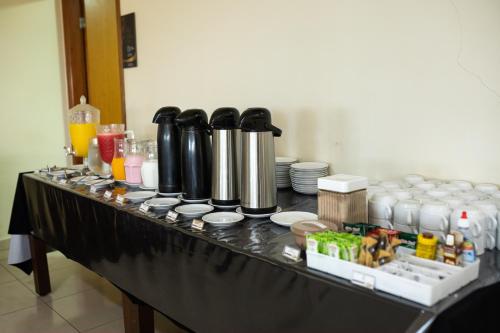 a table with a bunch of items on it at Class Hotel Passos Rio Grande Portal da Canastra in Passos