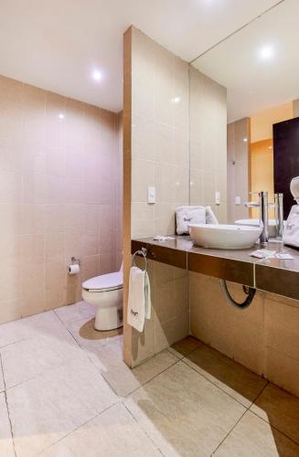 a bathroom with a sink and a toilet at First Inn Hotel & Business in Texcoco de Mora