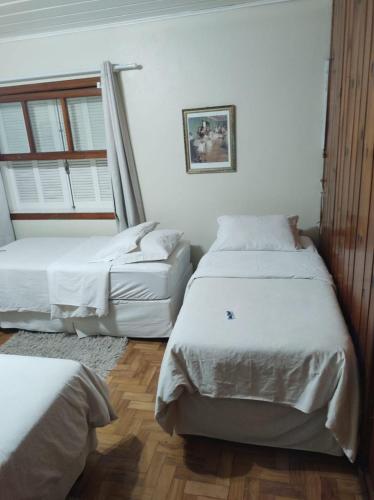 a bedroom with two beds and a window at Siena Hotel in Campos do Jordão