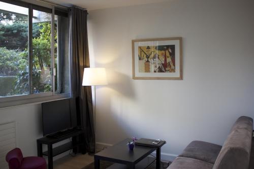 een woonkamer met een bank, een tafel en een raam bij Tour Eiffel Grenelle in Parijs