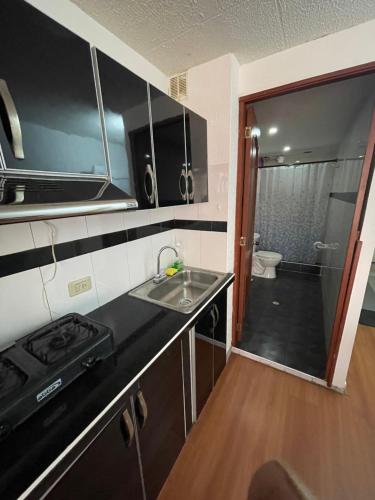 cocina pequeña con fregadero y baño en Apt estudio calle97302, en Bogotá