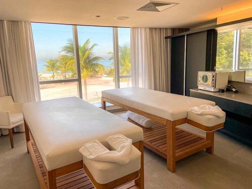 a dining room with a table and a view of the ocean at Hotel Nacional Vista Mar c/ Banheira in Rio de Janeiro