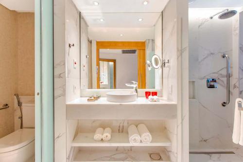 a bathroom with a sink and a shower and a toilet at Hotel Nacional Vista Mar c/ Banheira in Rio de Janeiro