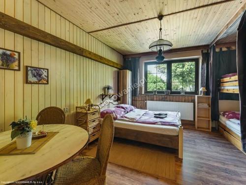 1 dormitorio con 1 cama y 1 mesa en Guesthouse Eden, en Liptovský Mikuláš