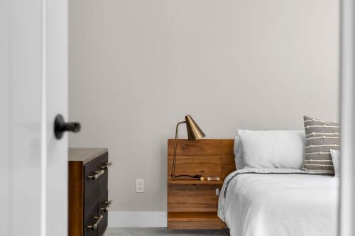 a bedroom with a bed and a wooden dresser at Park 202 Downtown in the Heart of Traverse City in Traverse City