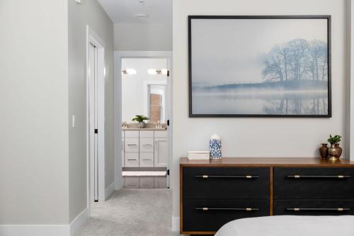 a bedroom with a dresser and a picture on the wall at Park 202 Downtown in the Heart of Traverse City in Traverse City