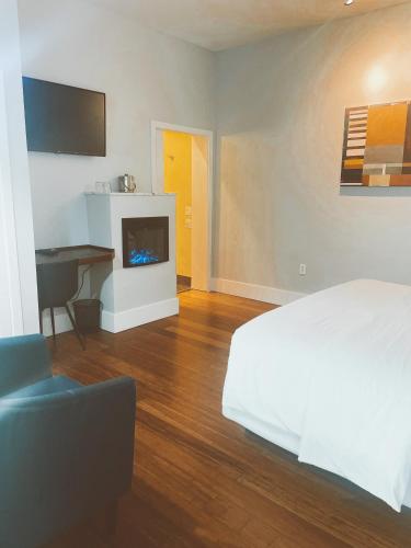a bedroom with a white bed and a fireplace at Pacific Blue Inn in Santa Cruz