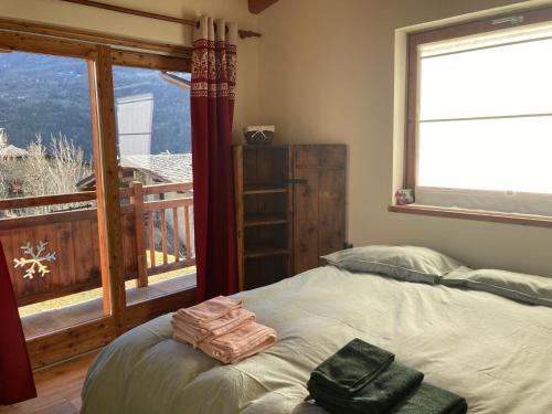 a bedroom with a bed and a large window at Chalet Gorret in Torgnon
