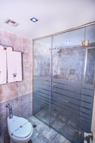 a bathroom with a glass shower and a toilet at Motel Mediterraneo in Mexicali