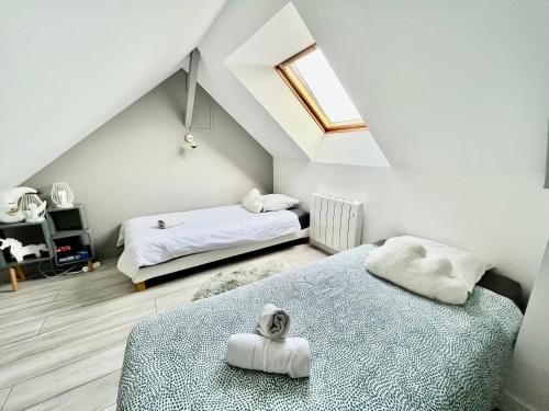 a attic bedroom with two beds and a skylight at Escapade marine in Deauville