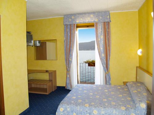 um quarto de hotel com uma cama e uma janela em Hotel Beata Giovannina em Verbania