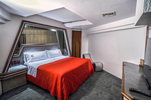 een slaapkamer met een rood bed en een raam bij Motel Mediterraneo in Mexicali