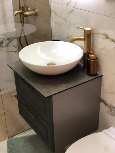 a bathroom with a white sink on a black counter at Villa Emili in Posušje