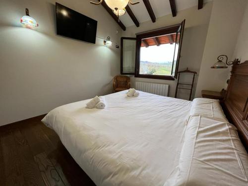 a bedroom with a large white bed with towels on it at VILLA DOLARETXE by Urdaibai Rentals in Bilbao