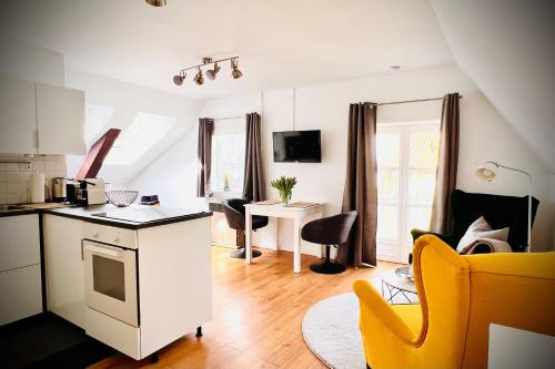 a kitchen and living room with a table and yellow chairs at Das Stader Nest in Stade