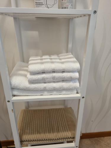a white towel shelf with towels on it at Appartamento Valentinis 74 in Monfalcone