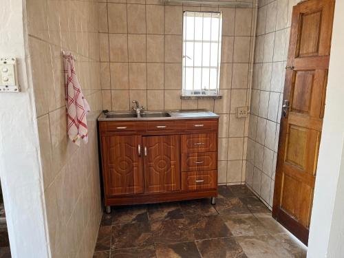 a small bathroom with a sink and a window at Eldos Guest House in Soweto