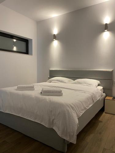 a bedroom with a large white bed with two pillows at MODERN House in Sighetu Marmaţiei