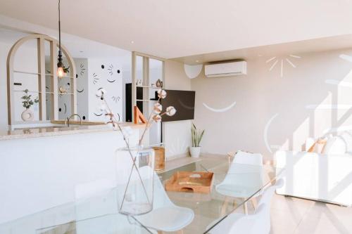 een woonkamer met een glazen tafel en witte stoelen bij O & D’s Gallery Apartment in San Salvador