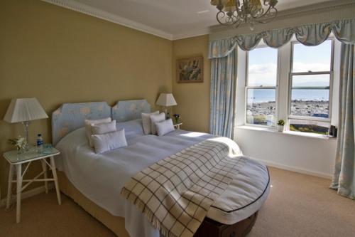 Un dormitorio con una cama grande y una ventana. en Loch Gorm House, en Bruichladdich