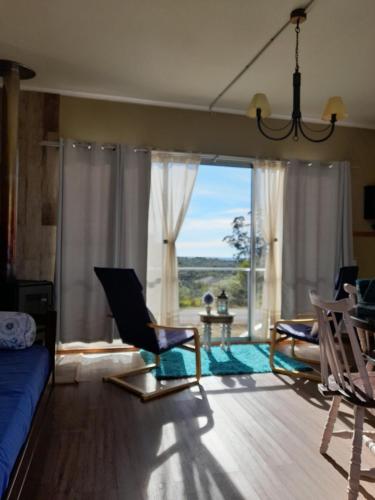 a living room with chairs and a large window at Aroma de la sierra in Villa Serrana