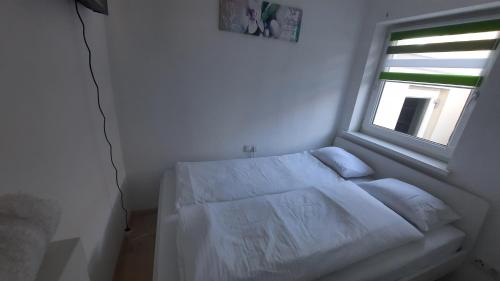 - un lit blanc dans une chambre avec fenêtre dans l'établissement Green Hill Rooms, à Feldkirch