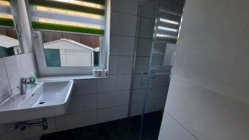 a bathroom with a sink and a mirror at Green Hill Rooms in Feldkirch