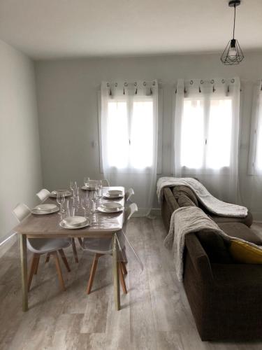 un salon avec une table et un canapé dans l'établissement Appartement cosy et lumineux, à Caussens