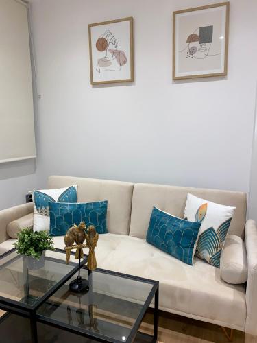 a living room with a white couch with blue pillows at villaboutique Jaén in Jaén