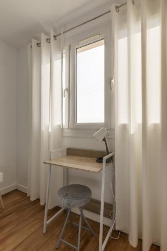 a desk and a chair in a room with a window at Grand Parking gratuit, De 1 à 4 personnes, Tout équipé, Netflix, Amazon Prime Gratuits et Illimités, Matelas Emma, Lave Linge, Vue sur la Vallée, RDC in Pont-Hébert