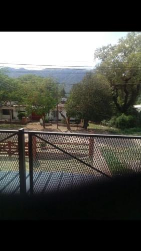 a chain link fence with a view of a park at Santa María de punilla in Santa María
