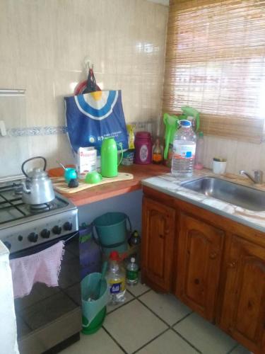 um balcão de cozinha com um lavatório e um fogão em Santa María de punilla em Santa María